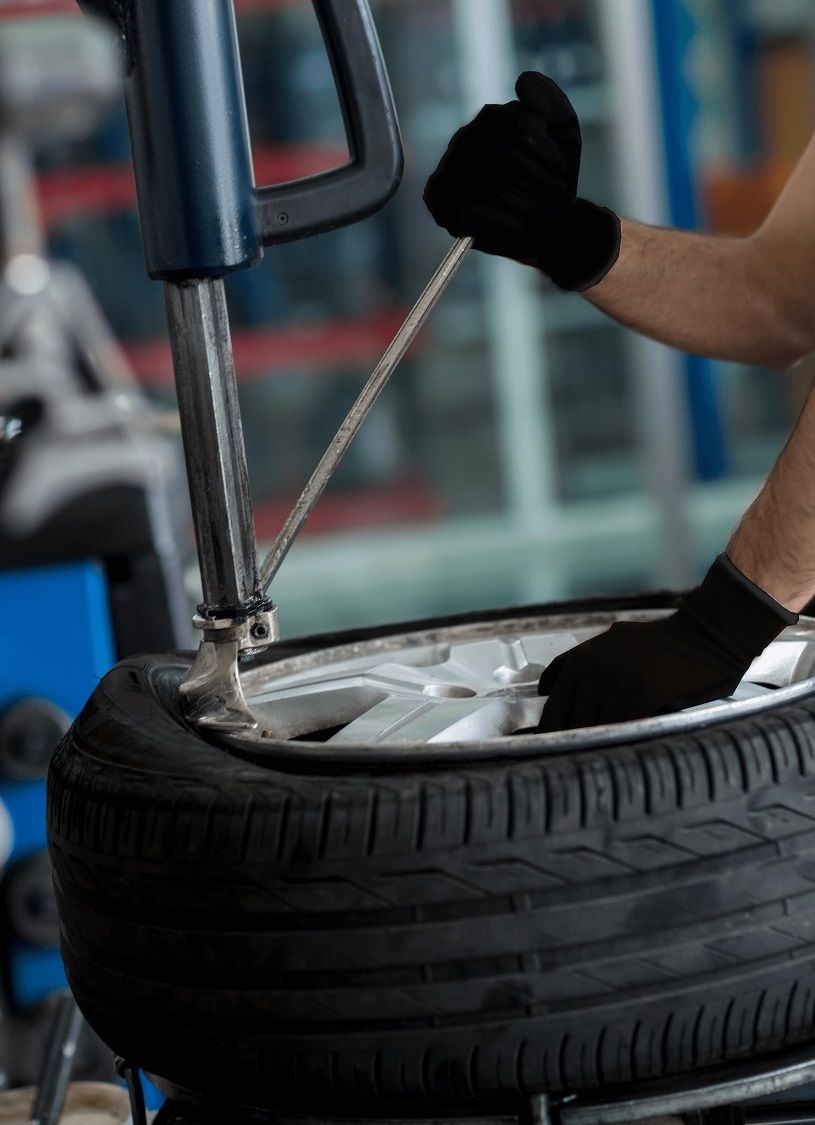A Fit & Fix worker repairing a car wheel. 