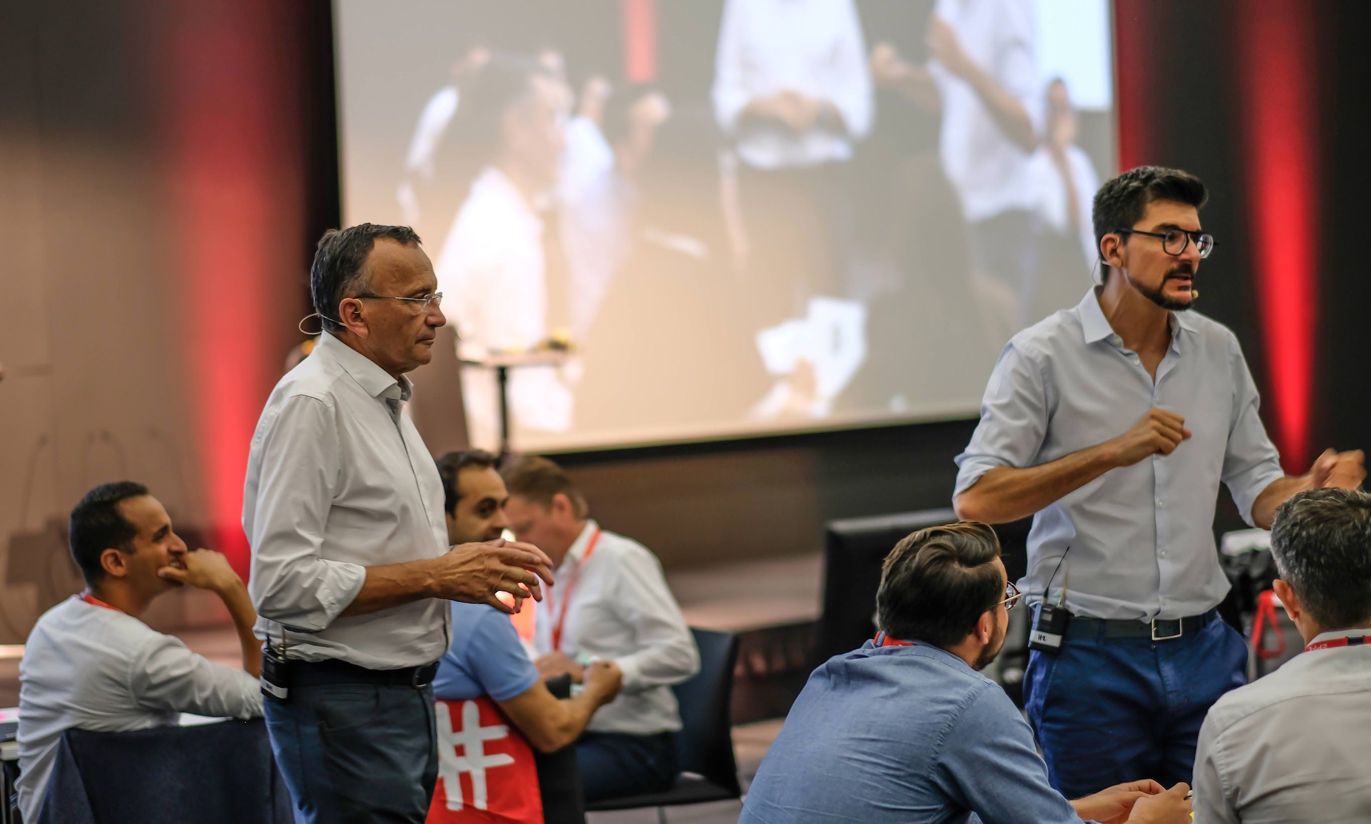 Two people shown giving a talk on stage.