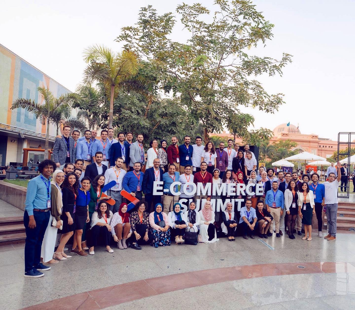 Group photo with Robusta employees gathered around the e-commerce summit sign.